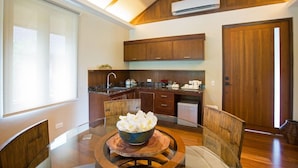 Una cocina moderna con armarios de madera, una mesa de comedor con sillas y un cuenco de flores blancas.