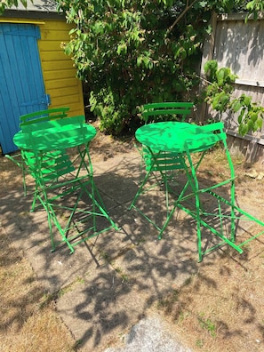 Two green metal chairs and a table set outdoors on a paved surface. - Spacious coastal apartment with garden, sleeps 6 (West Sussex)