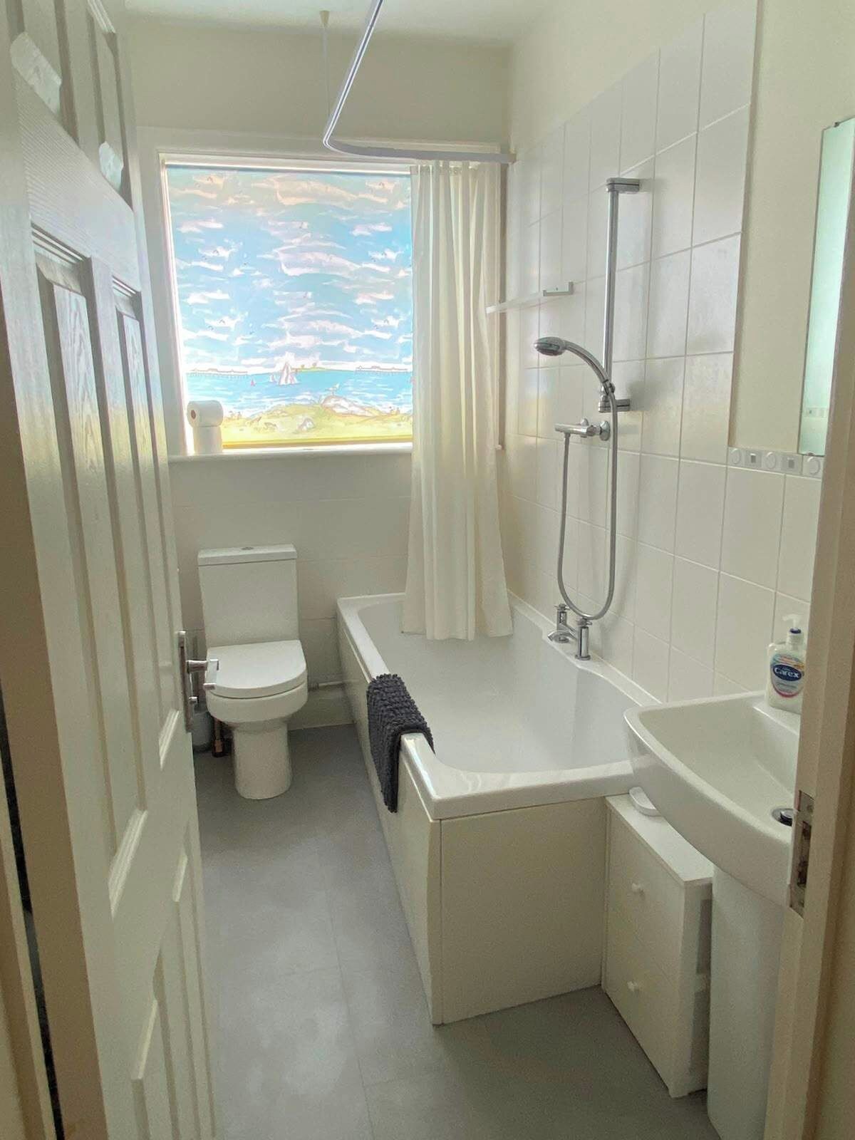 Une salle de bain compacte comprenant des toilettes, une baignoire et une douche.
