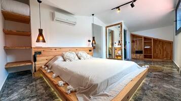 A modern bedroom with a large bed, wooden headboard, and built-in shelving.