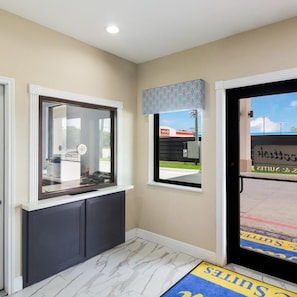 A room with a window, a door, and a view of a building outside. - Scottish Inns and Suites Hitchcock TX (Hitchcock)