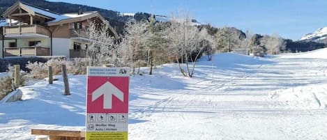 Estación de esquí cubierta de nieve con un cartel que indica la dirección de un telesilla.