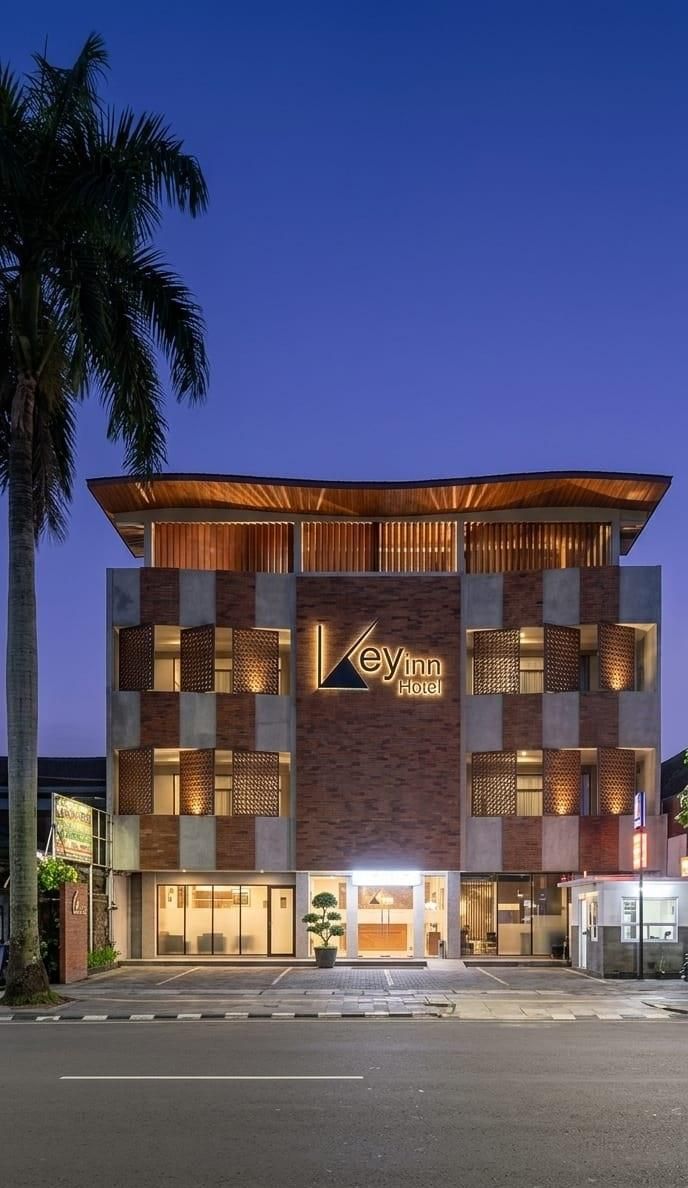 A Key Inn Hotel with a modern design, featuring a prominent sign, multiple levels, and a well-lit entrance.