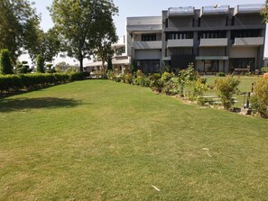 A grassy courtyard with a modern building in the background.