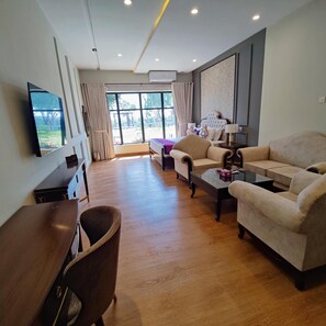 Una sala moderna con un conjunto de sofás, una mesa de centro y un televisor montado en la pared.