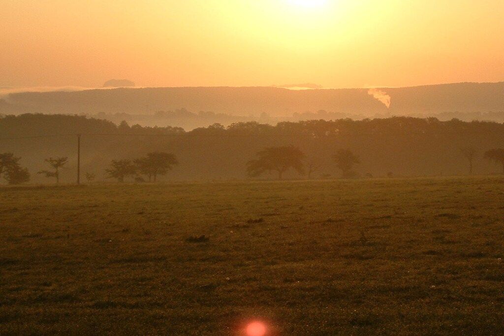 A flat landscape with a horizon line and a distant tree line.