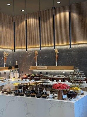 Una mesa de buffet con diferentes alimentos y utensilios.