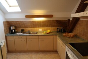 A compact kitchen with a sink, stove, and a skylight. - Holiday apartment with 2 bedrooms (Bahretal)