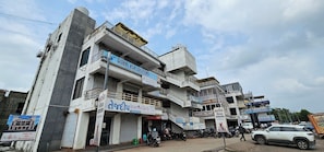 A multi-story building with commercial establishments on the ground floor, including a travel visa service and a medical clinic.