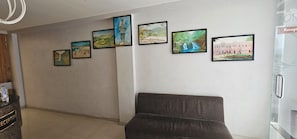 A reception area with a sofa, a water dispenser, and a wall with framed pictures.