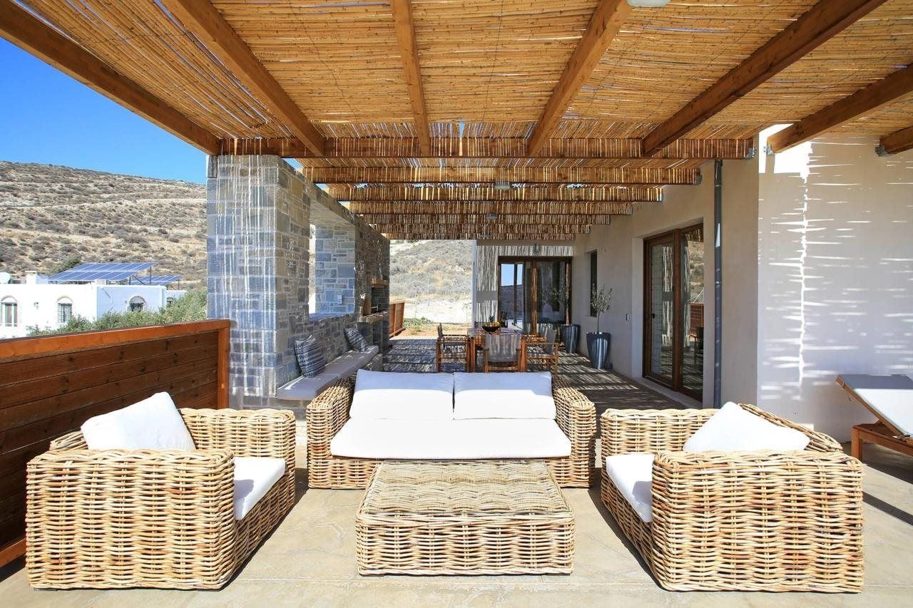 An outdoor patio area with wicker furniture and a view of the surrounding landscape.