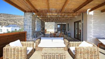 An outdoor patio area with wicker furniture and a view of the surrounding landscape.
