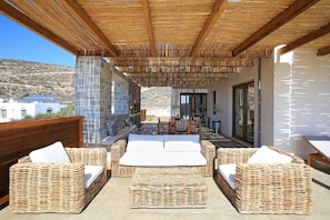 An outdoor patio area with wicker furniture and a view of the surrounding landscape.