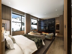 Une chambre moderne dotée d’un grand lit, d’un coin salon avec une cheminée et d’un téléviseur fixé à un mur en pierre.