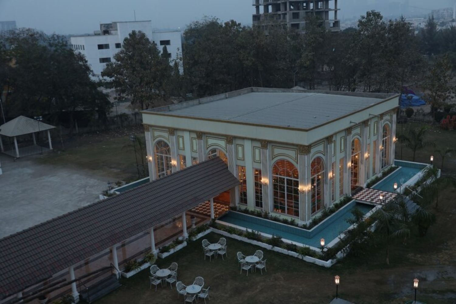 A large building with a pool and outdoor seating area.