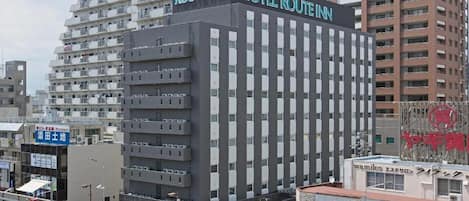 Un hotel de varios pisos con fachada moderna, que presenta un letrero llamativo del Hotel Route Inn.