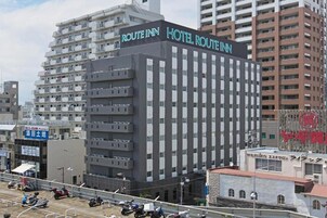 Un hotel de varios pisos con fachada moderna, que presenta un letrero llamativo del Hotel Route Inn.