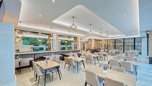Un restaurante moderno con diversas opciones de asientos, incluyendo cabinas y mesas.
