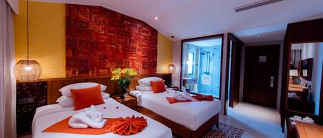 Habitación de hotel con dos camas, una pared de acento roja, un ventanal grande y un diseño moderno.