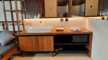 A modern bathroom with a wooden vanity, a built-in sink, and a mirror.