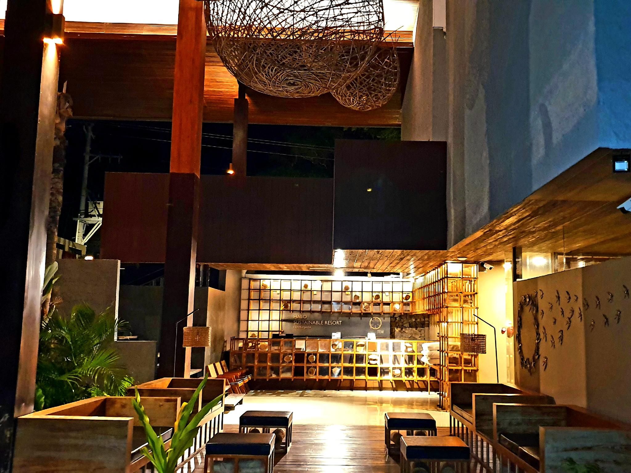 A spacious indoor area with a seating arrangement, a decorative ceiling, and a wall with a unique pattern.