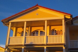 Un edificio a due piani con un balcone al piano superiore.