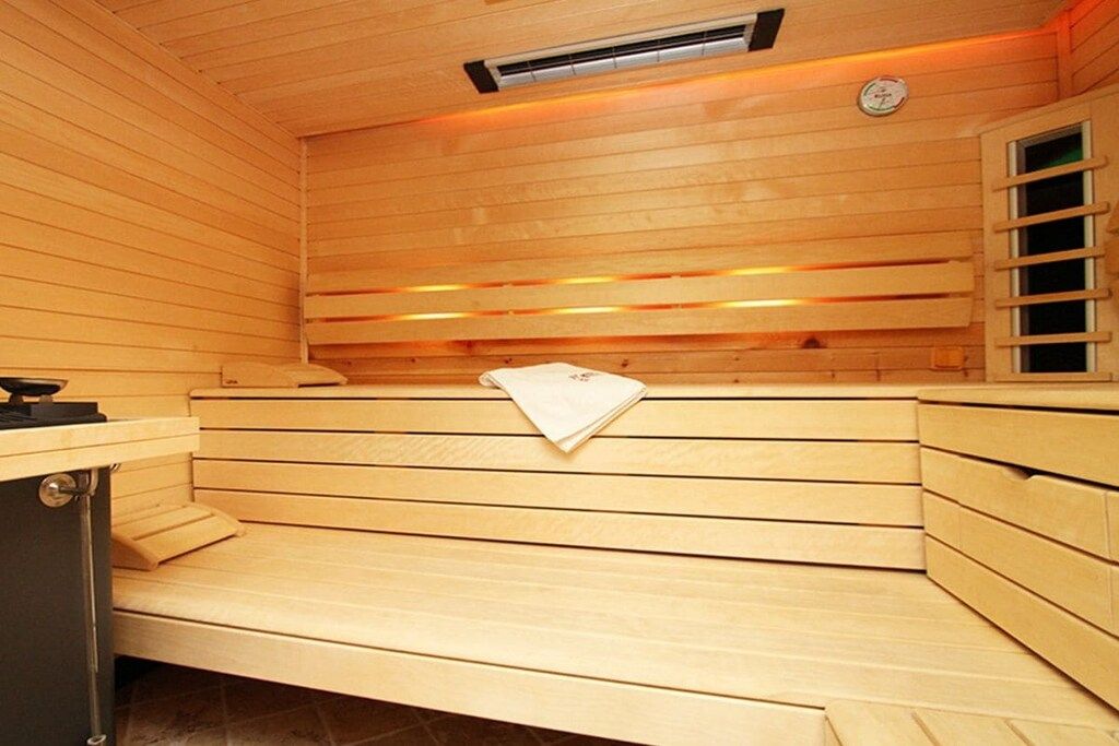 Un sauna avec des bancs en bois et un système de chauffage intégré aux bancs.