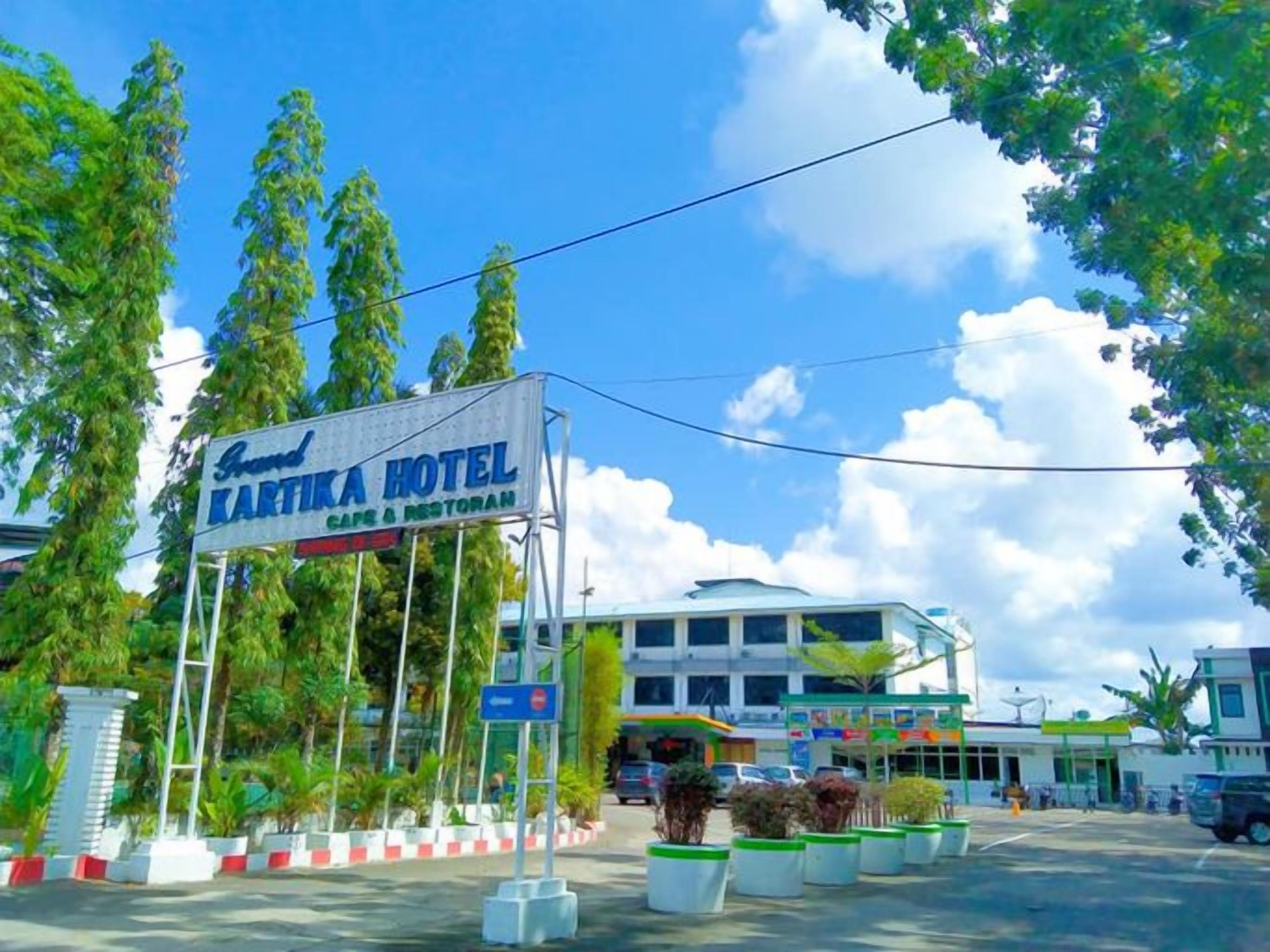 A hotel sign with 'Grand Kartika Hotel' and 'Cafe & Restaurant' written on it.