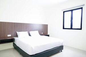 A modern bedroom with a bed, nightstands, and a window.