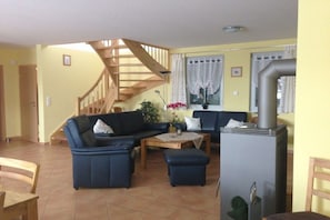 A living room with a sofa set, a coffee table, and a fireplace. - Holiday home in Glowe with swimming pool (Glowe)
