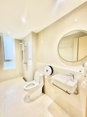Un baño moderno con inodoro, bidé y lavabo.