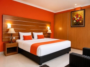 Quarto de hotel com uma cama grande, duas mesas de cabeceira com luminárias, uma cabeceira de madeira e um quadro na parede.