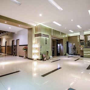 A hotel lobby with a reception desk, a staircase, and a sign that reads 'Hello!'. - Akasia Budget Hotel (Promong)