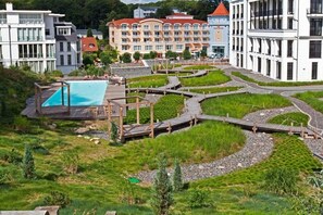 A resort with a swimming pool, wooden walkways, and a landscaped garden. - Holiday apartment with 2 bedrooms (Sellin)