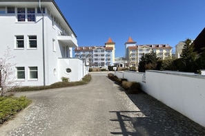 A paved pathway leading to a building with a white facade and multiple windows. - Holiday apartment with 1 bedroom (Zinnowitz)