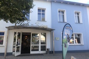 Een gebouw met een bord waarop 'Club Kino' staat en een spandoek met de tekst 'Peace Love & Ice Cream'.