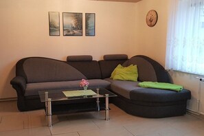 Ein Wohnzimmer mit einer Couch, einem Couchtisch und einer Wanduhr.