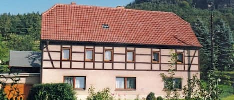 A two-story building with a red-tiled roof and a symmetrical facade.