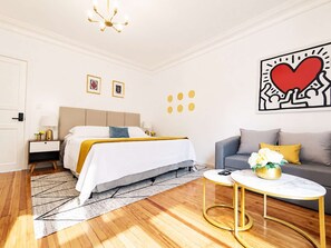 A modern hotel room with a bed, a sofa, a coffee table, and a chandelier. - Laila Casa + Luz María 5 y 6 · Polanco, sleeps 19 · 6.5 baths (Ciudad de México)