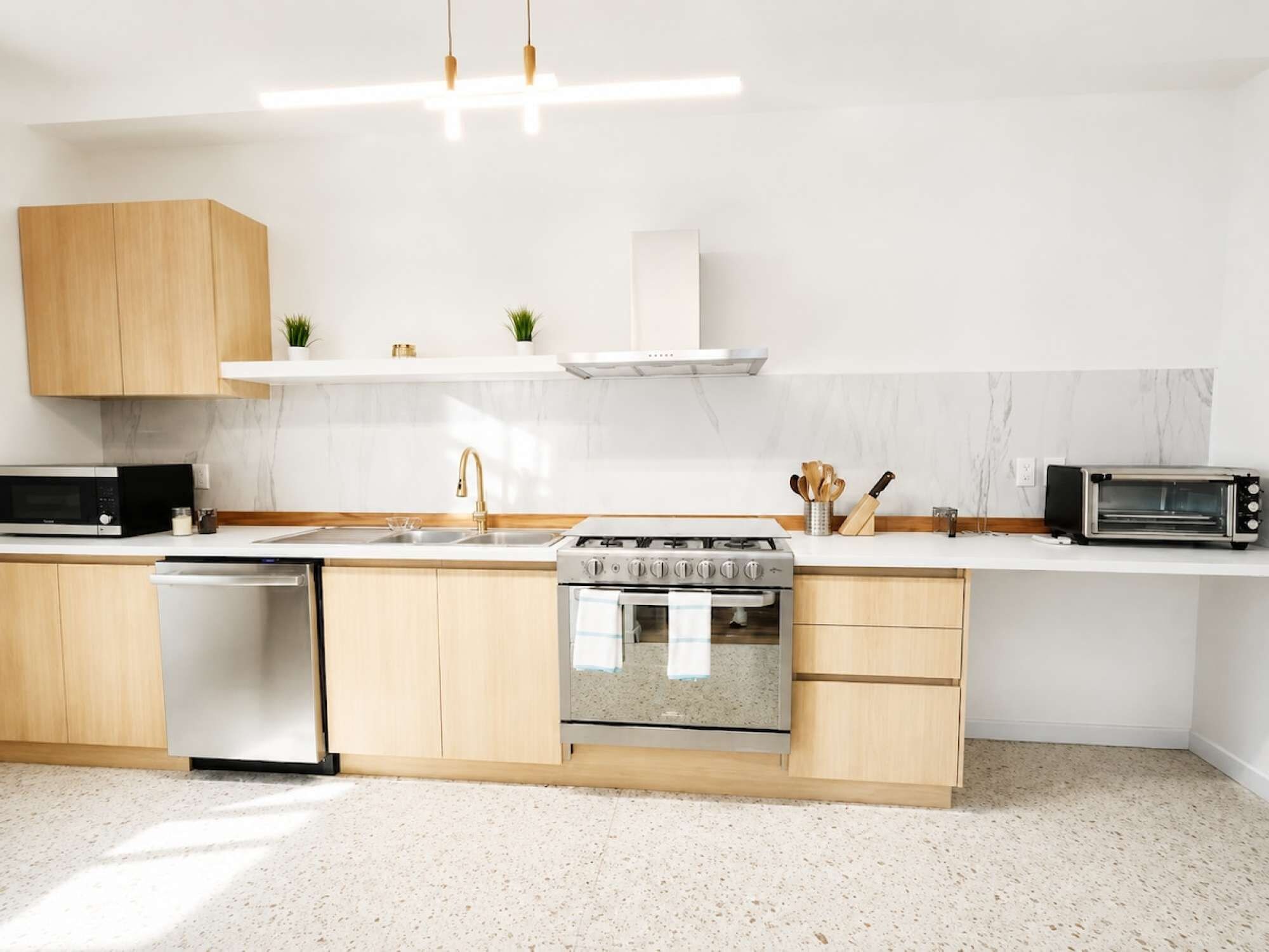 Cozinha moderna equipada com forno embutido, micro-ondas e máquina de lavar louça.