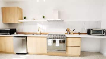 Cozinha moderna equipada com forno embutido, micro-ondas e máquina de lavar louça.