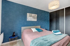 A bedroom with a bed, a nightstand, a decorative item, and a wall-mounted artwork. - Holiday home 'Petite Maison de Kervenou' with private terrace, garden and Wi-Fi (Goudelin)