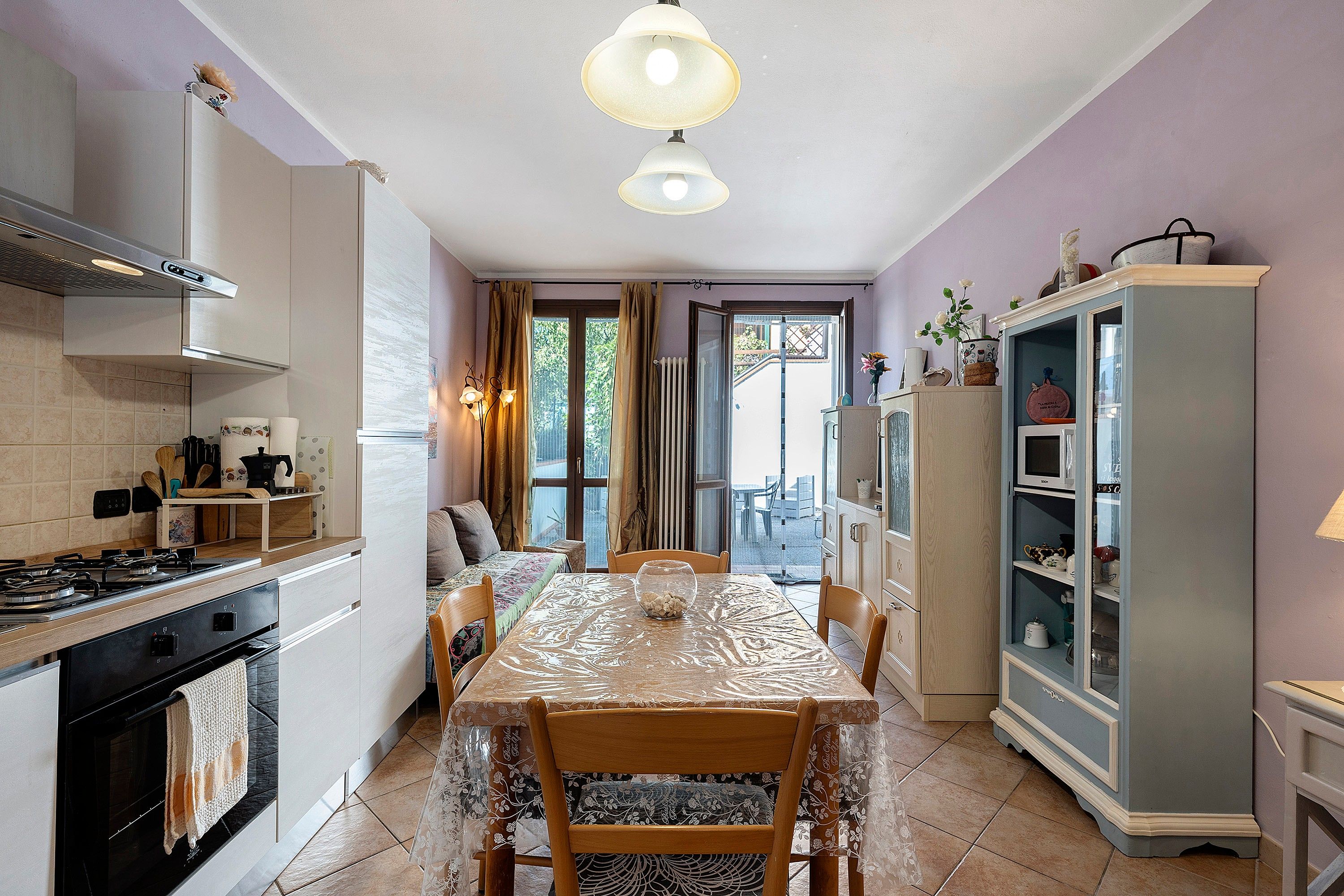 Een keuken met een eettafel, stoelen, een koelkast en een fornuis.