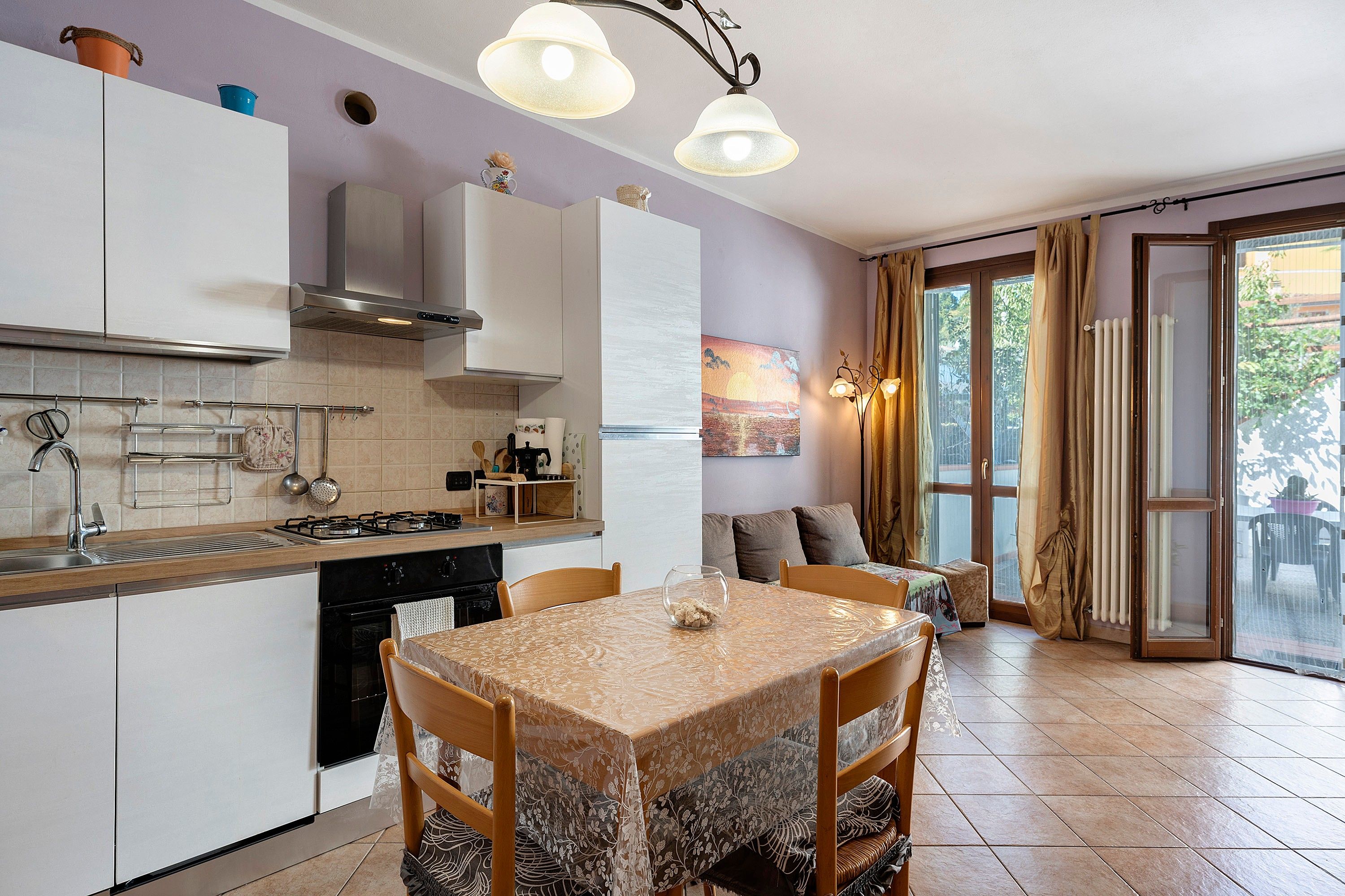 Een moderne keuken met een eethoek, met een fornuis, spoelbak en kasten.