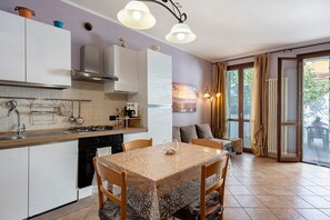A modern kitchen with a dining area, featuring a stove, sink, and cabinets. - Holiday Home 'La Casa di Monica' with Private Garden and Wi-Fi (Pescia)