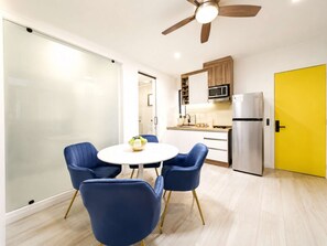 A modern kitchen with a microwave, refrigerator, and wooden cabinets. - Coco 1&2 · Two suites with terrace in Condesa · 2 baths (Ciudad de México)