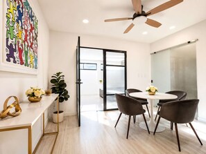 A modern office space with a round table, black chairs, a ceiling fan, and a glass door leading to another room. - Coco 4&5 · Two suites with terrace in Condesa · 2 baths (Ciudad de México)