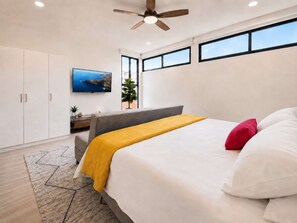 A bedroom with a bed, a television, a ceiling fan, and a window. - Coco 7&8 · Two suites with terrace in Condesa · 2 baths (Ciudad de México)