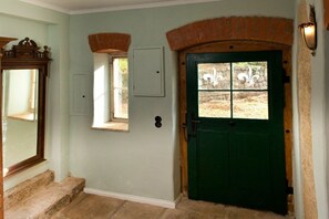 A green door with a window, a mirror, and a light fixture on the wall. - Old Forester's Lodge Hohnstein (Hohnstein)