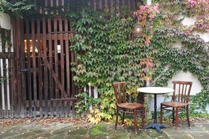 A wooden gate, a wall covered with ivy, and two wooden chairs with a small round table. - Old Forester's Lodge Hohnstein (Hohnstein)